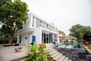 a white building with a swimming pool in front of it at LaVa Haus Homestay Hòa Bình - Venuestay in Hòa Bình