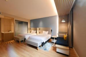 a hotel room with two beds and a bench at Holiday Inn Express Tianjin Binhai by IHG in Binhai +64 photos
