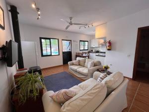a living room with two couches and a kitchen at Padre Aviles in Olías