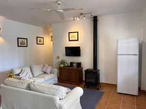 a living room with two white couches and a stove at Padre Aviles in Olías