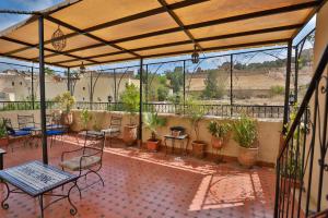 patio ze stołami, krzesłami i roślinami w obiekcie DAR EL AAMOURI w Fezie