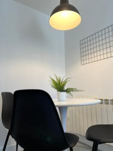 a black chair sitting next to a table with a plant at Apartamento Villamediana Suite in Villamediana de Iregua