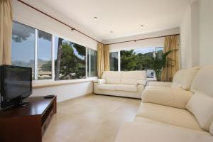 カラ・デ・サント・ビセントにあるVilla Medinaのリビングルーム(白い家具、大きな窓付)