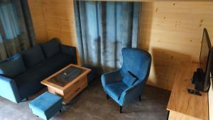 salon z kanapą, krzesłem i stołem w obiekcie Domek nad Nieliszem w mieście Nielisz