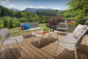 eine Terrasse mit 3 Stühlen, einem Tisch und einem Tisch in der Unterkunft Chalet Ysopi - OVO Network in Saint-Jean-de-Sixt