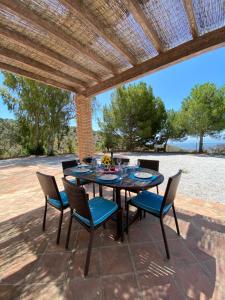 a patio with a table and chairs under a pergola at Padre Aviles in Olías