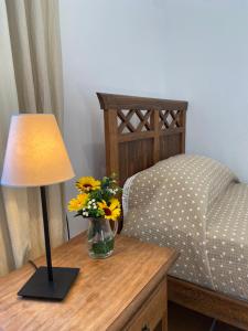 a table with a lamp and a vase with flowers on it at Padre Aviles in Olías