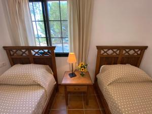 a bedroom with two beds and a table with a lamp at Padre Aviles in Olías