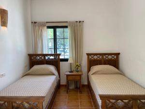 two twin beds in a room with a window at Padre Aviles in Olías