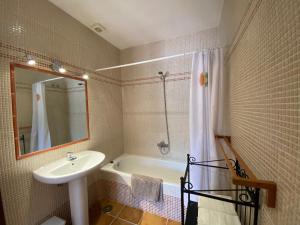a bathroom with a sink and a tub and a mirror at Padre Aviles in Olías