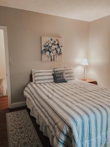 een slaapkamer met een bed met een blauwe en witte deken bij River Place Condos #205 2BD in Pigeon Forge