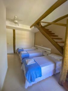 una fila de camas azules en una habitación en Beachcamp Maresias, en Maresias
