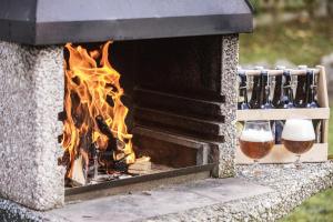 a fireplace with two glasses of beer and a fire at Penzion Linden 