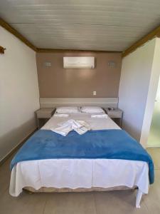 una camera con un letto e una coperta blu di Beachcamp Maresias a Maresias