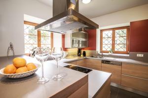 a kitchen with a bowl of fruit and two wine glasses at Penzion Linden 