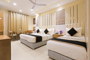 Cette chambre comprend 2 lits et une table. dans l'établissement Hotel Worth - Near Railway Station, à New Delhi