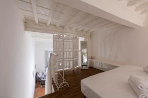 - une chambre avec un lit blanc et un balcon dans l'établissement Toscanella Romantic, à Florence