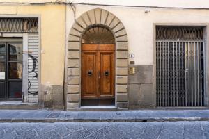 une porte en bois au milieu d'un bâtiment dans l'établissement Toscanella Romantic, à Florence