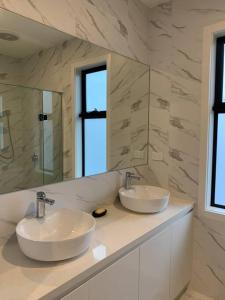 Baño con 2 lavabos y espejo en ‘The bayside’ Beautifully brand new house en Mentone