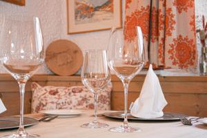 une table avec quatre verres à vin en haut dans l'établissement Hotel Solaria, à Bivio