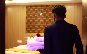 a man standing in front of a pile of towels at Hotel Emirates in Kānnangād