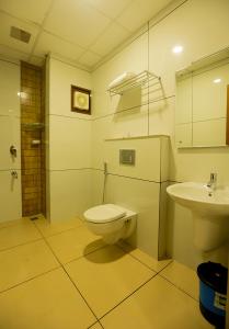 a bathroom with a toilet and a sink at Hotel Emirates in Kānnangād