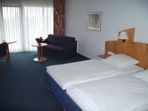 ein Hotelzimmer mit einem Bett und einem Sofa in der Unterkunft Hotel Görres in Wachtberg