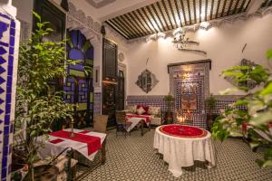 Pokój ze stołem, krzesłami i roślinami w obiekcie DAR EL AAMOURI w Fezie