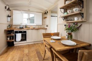 a kitchen with white cabinets and a wooden table at Wagtail in Greenhead