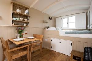 a room with a bed and a table and a bed at Wagtail in Greenhead