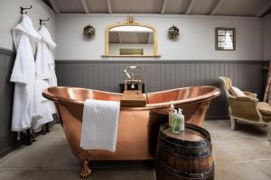 a bathroom with an old fashioned tub and a mirror at Wagtail in Greenhead