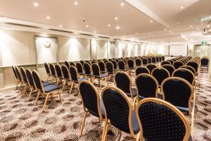 a room with rows of chairs in a room at Holiday Inn Brighton Seafront by IHG in Brighton & Hove