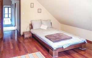 uma pequena cama num quarto com pisos em madeira em Amazing Home In Purda With Kitchen em Purda