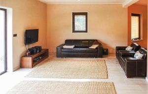 a living room with a leather couch and a flat screen tv at Amazing Home In Purda With Kitchen in Purda