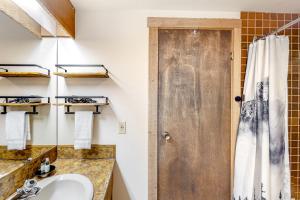 a bathroom with a sink and a shower at Moguls 813 in Big White