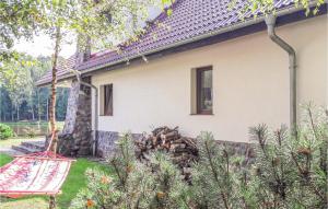 a house with a pile of logs in the yard at Four-Bedroom Holiday Home In Purda in Purda