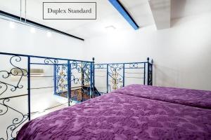 una camera con letto viola e piumone viola di Grand Hôtel du Bel Air a Parigi