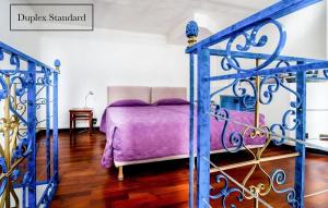um quarto com uma cama com um cobertor roxo em Grand Hôtel du Bel Air em Paris