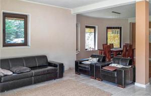a living room with black leather furniture and a dining room at Four-Bedroom Holiday Home In Purda in Purda +13 photos