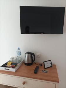 a tv on top of a wooden table with a coffee maker at Les Muches in Bouzincourt