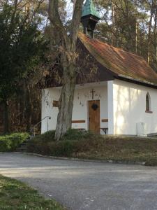 una pequeña iglesia blanca con un árbol delante en Ferienwohnung-Bayrisch-Nizza, en Sulzbach am Main