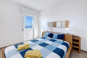a bedroom with a blue and white bed and a window at Casa Atlântico in Sesimbra