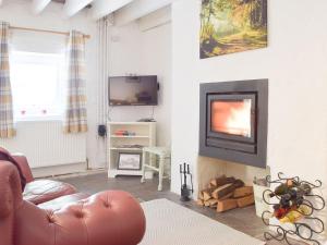 a living room with a couch and a television at Y Stabl - Uk35032 in Carmarthen