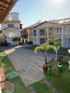 a courtyard of a apartment building with a palm tree at Mont Carmelo Residencial Ap 5A Rede Tonziro in Porto Seguro
