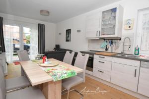 eine Küche und ein Wohnzimmer mit einem Holztisch in der Küche in der Unterkunft Pension Lütje Huske Zimmer4 in Südbrookmerland