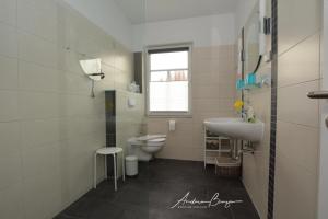 a bathroom with a toilet and a sink at Pension Lütje Huske Zimmer 1 in Südbrookmerland