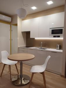 a kitchen with a wooden table and two white chairs at Apartament Gliwice centrum, z garażem in Gliwice