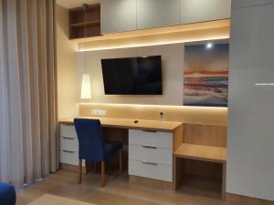 biurko z telewizorem i niebieskim krzesłem w obiekcie Apartament Gliwice Górnych Walów w mieście Gliwice