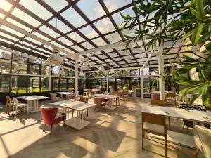 a restaurant with tables and chairs and a glass ceiling at Grand Royal Hotel in Poznań