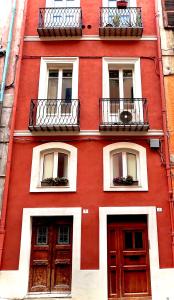 un edificio rosso con due porte e due balconi di Remy apartment a Cagliari